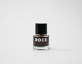 Small glass bottle with black cap and 'ROCK' label on a white background